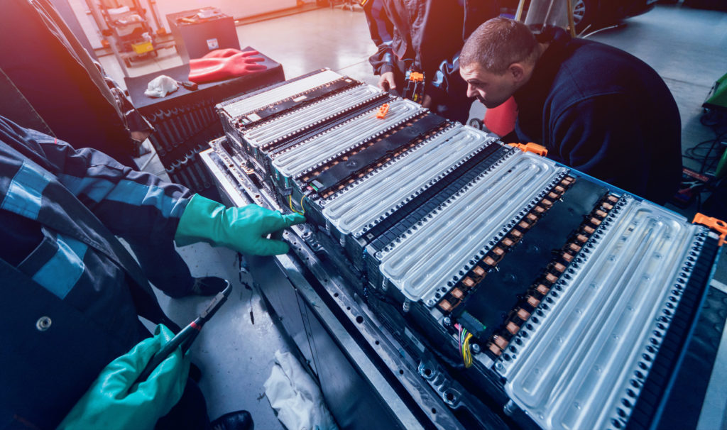 Mechanics working on an electric car battery